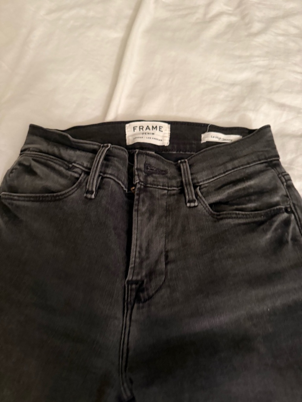 Frame Denim Washed Black Skinny Jeans with frayed asymmetrical detail